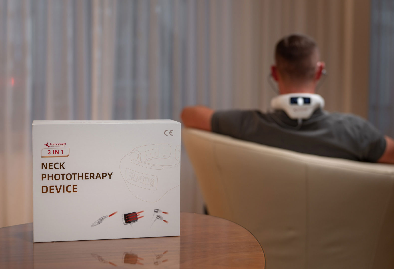 LumoHome Verpackung & Anwendung LumoHome Produktverpackung im Vordergrund, im Hintergrund eine Anwenderin mit aktiviertem Lasergerät